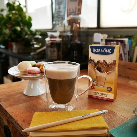 a cup of coffee sitting on top of a wooden table