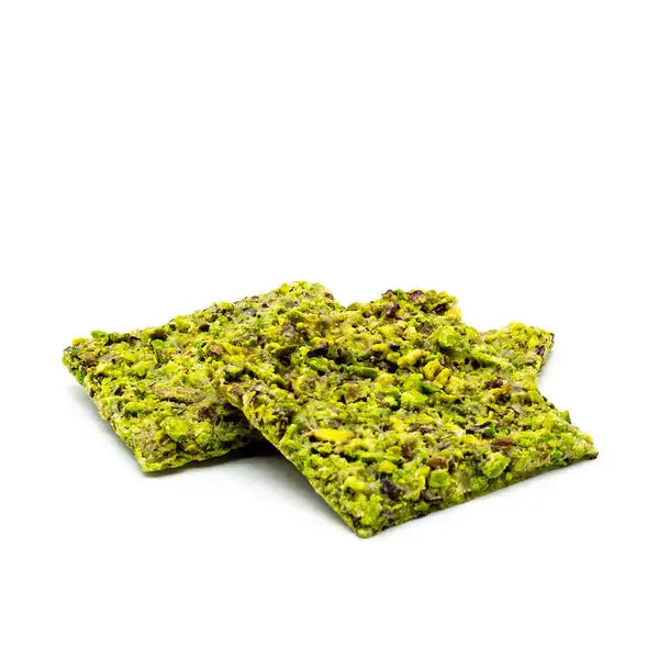 two pieces of pistachio crunch on a white background