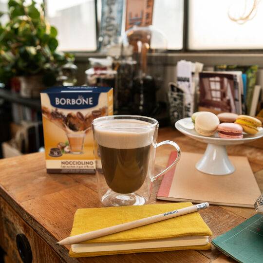 a cup of coffee sitting on top of a wooden table