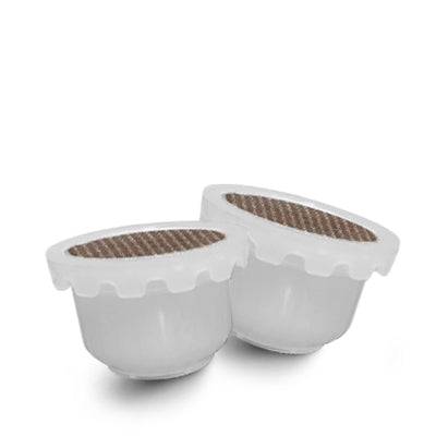 two Domo coffee capsules sitting on top of each other